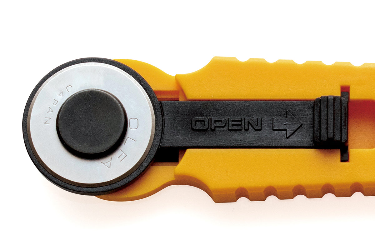 Photo of OLFA RTY-4 18mm Classic Straight Rotary Cutter with blade cover for safety storage, designed for precision cutting in sewing and crafting.