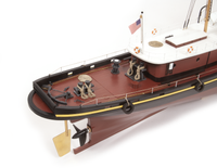 A detailed model of a tugboat, shown from an elevated rear angle on a clean white background. The boat features a dark reddish-brown hull, a white superstructure, a black deck, and a gold-colored brass propeller.