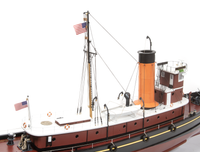 A detailed model of a tugboat, shown from a side angle against a plain white background. The boat features a dark reddish-brown hull, a white upper deck, a prominent orange smokestack, and black details including rigging, fenders, and an American flag flying from the mast.