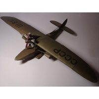 A vintage-style model airplane with olive drab green paint, featuring 'CCCP' and 'W88M' markings on the wings, photographed on a plain light background.