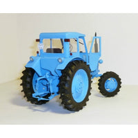 A light blue model tractor with black tires, photographed against a plain off-white background.