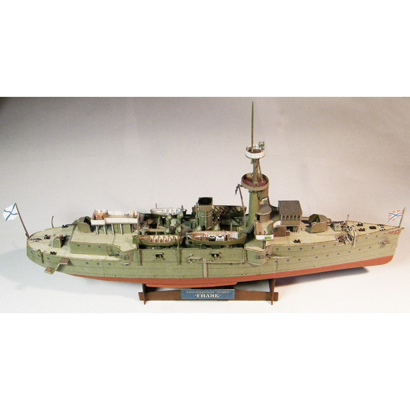 A detailed model of the historical battleship HMS T-ANK, displayed on a wooden stand against a neutral light gray background.