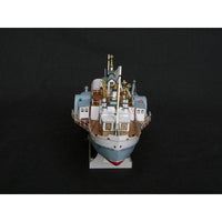 A detailed model of a cargo ship, photographed from a high angle against a solid black background.