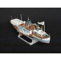 A detailed model of a passenger steamship with white and light blue hulls, brown wooden decks, and gold-domed masts, mounted on a display stand against a black background.