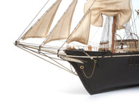 Photo of OcCre Endurance 1:70 wooden model ship kit with sails, nameplate, and detailed wooden construction