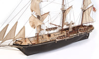 Photo of OcCre Endurance 1:70 wooden model ship kit with sails, nameplate, and detailed wooden construction