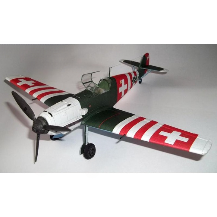 A model Swiss Air Force fighter plane, likely a Fieseler Fi 110, featuring a dark green fuselage, white nose and tail sections, and red-and-white striped wings with white Swiss crosses.