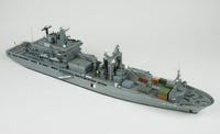 A detailed model of a gray military cargo ship, shown from a high-angle perspective against a plain light gray background.