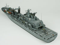 A detailed model of a gray military cargo ship, shown from an elevated three-quarters perspective against a seamless light gray background.