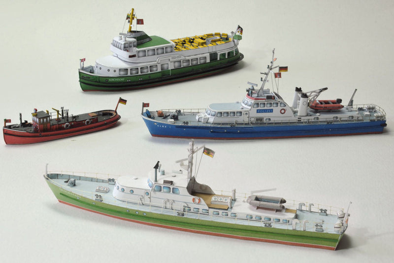 Photo of HMV Hamburg Museum Ships Card Model Kit 103342 showing four detailed paper ship models – Feuerwehr IV, Kirchdorf, Glückstadt, and Elbe 1 – in 1/250 scale
