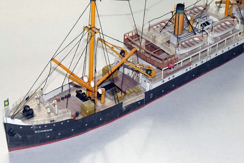 Photo of HMV Steamer Schwan II card model kit 1:250 showing detailed paper parts and assembled model of the 1907 German passenger and freight ship.