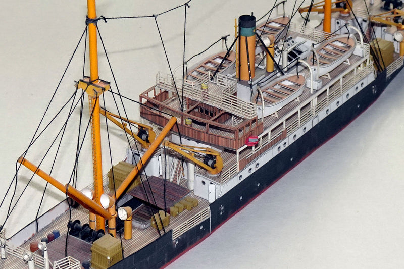 Photo of HMV Steamer Schwan II card model kit 1:250 showing detailed paper parts and assembled model of the 1907 German passenger and freight ship.