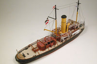 Photo of HMV Merkur and Vulkan 1/250 scale tugboat card model kit showing detailed steam tugs with printed parts and maritime accessories.