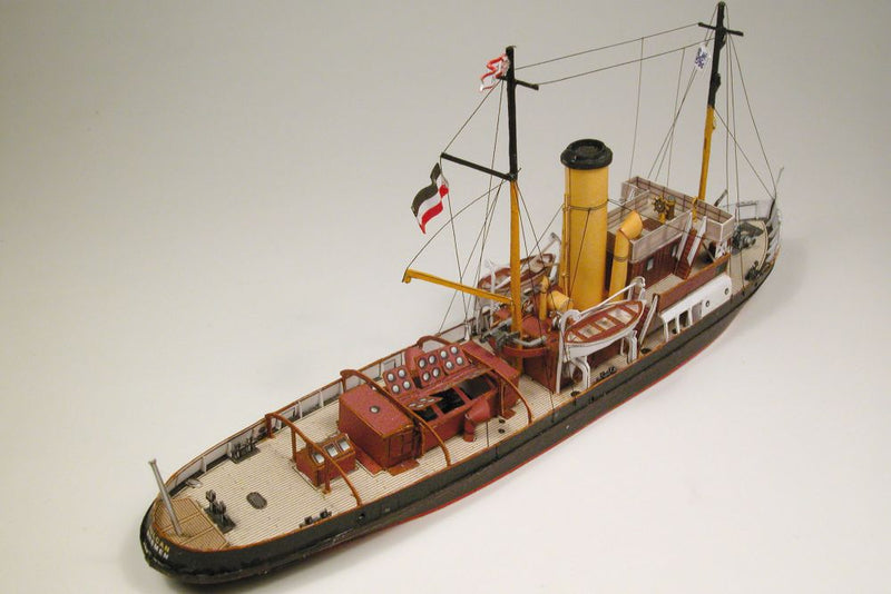 Photo of HMV Merkur and Vulkan 1/250 scale tugboat card model kit showing detailed steam tugs with printed parts and maritime accessories.