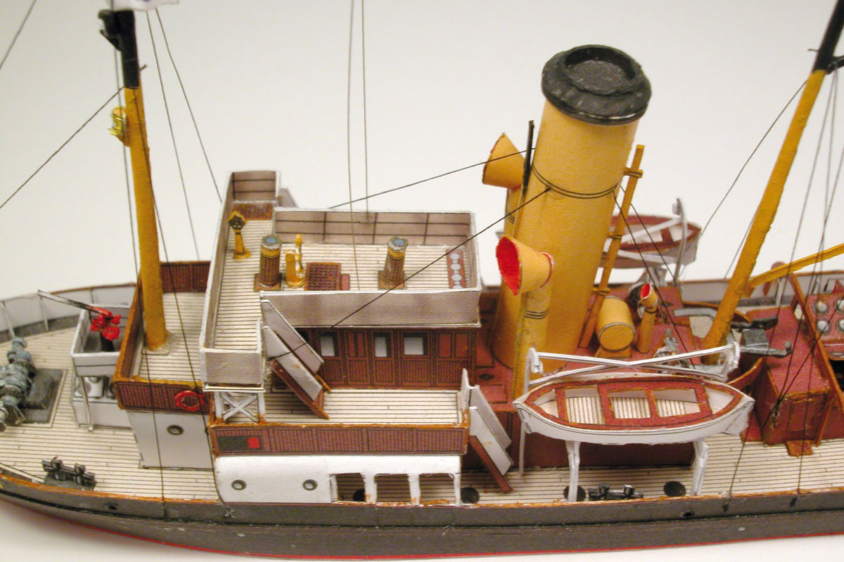 Photo of HMV Merkur and Vulkan 1/250 scale tugboat card model kit showing detailed steam tugs with printed parts and maritime accessories.