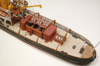 Photo of HMV Merkur and Vulkan 1/250 scale tugboat card model kit showing detailed steam tugs with printed parts and maritime accessories.