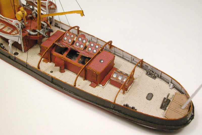 Photo of HMV Merkur and Vulkan 1/250 scale tugboat card model kit showing detailed steam tugs with printed parts and maritime accessories.