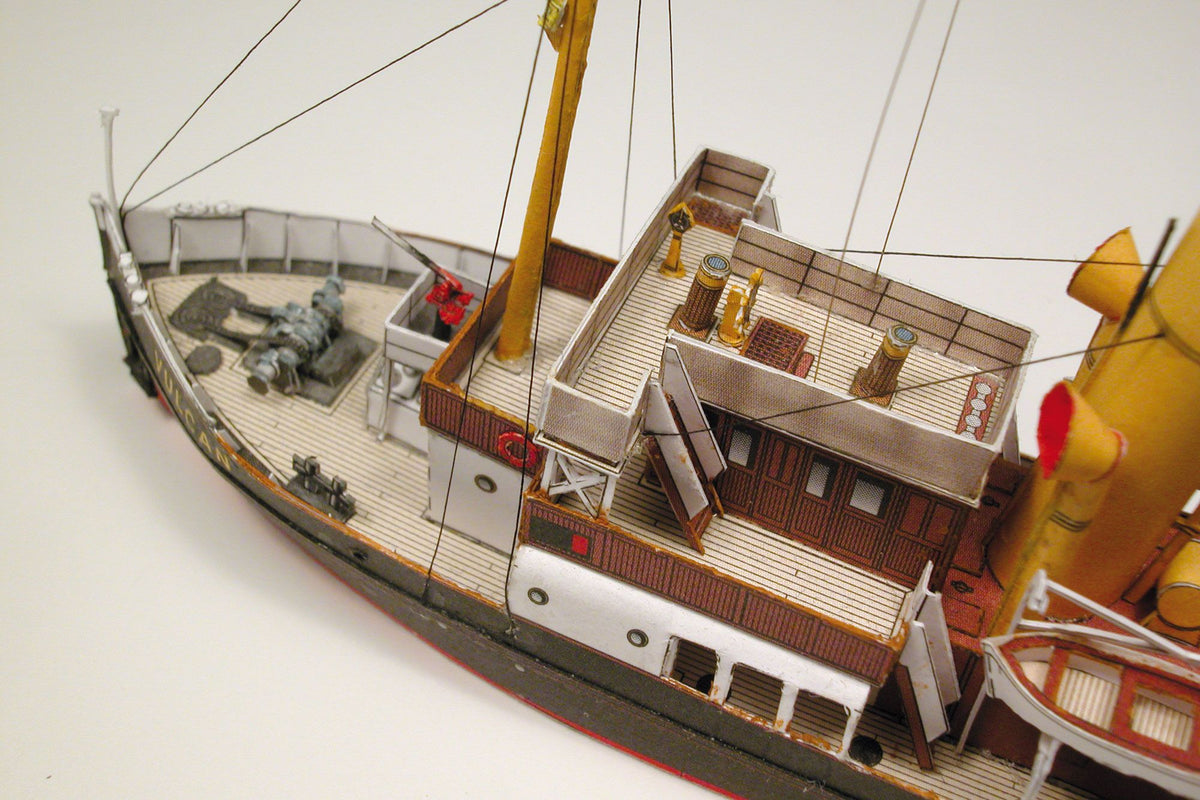 Photo of HMV Merkur and Vulkan 1/250 scale tugboat card model kit showing detailed steam tugs with printed parts and maritime accessories.