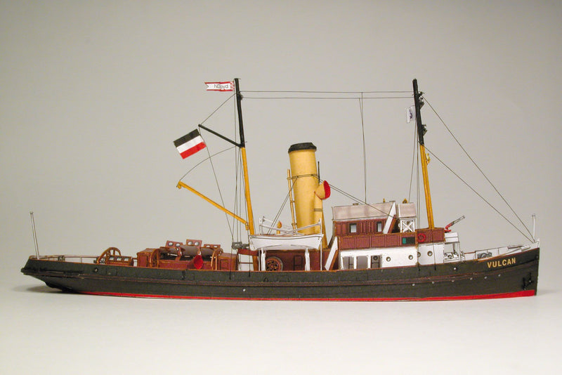 Photo of HMV Merkur and Vulkan 1/250 scale tugboat card model kit showing detailed steam tugs with printed parts and maritime accessories.
