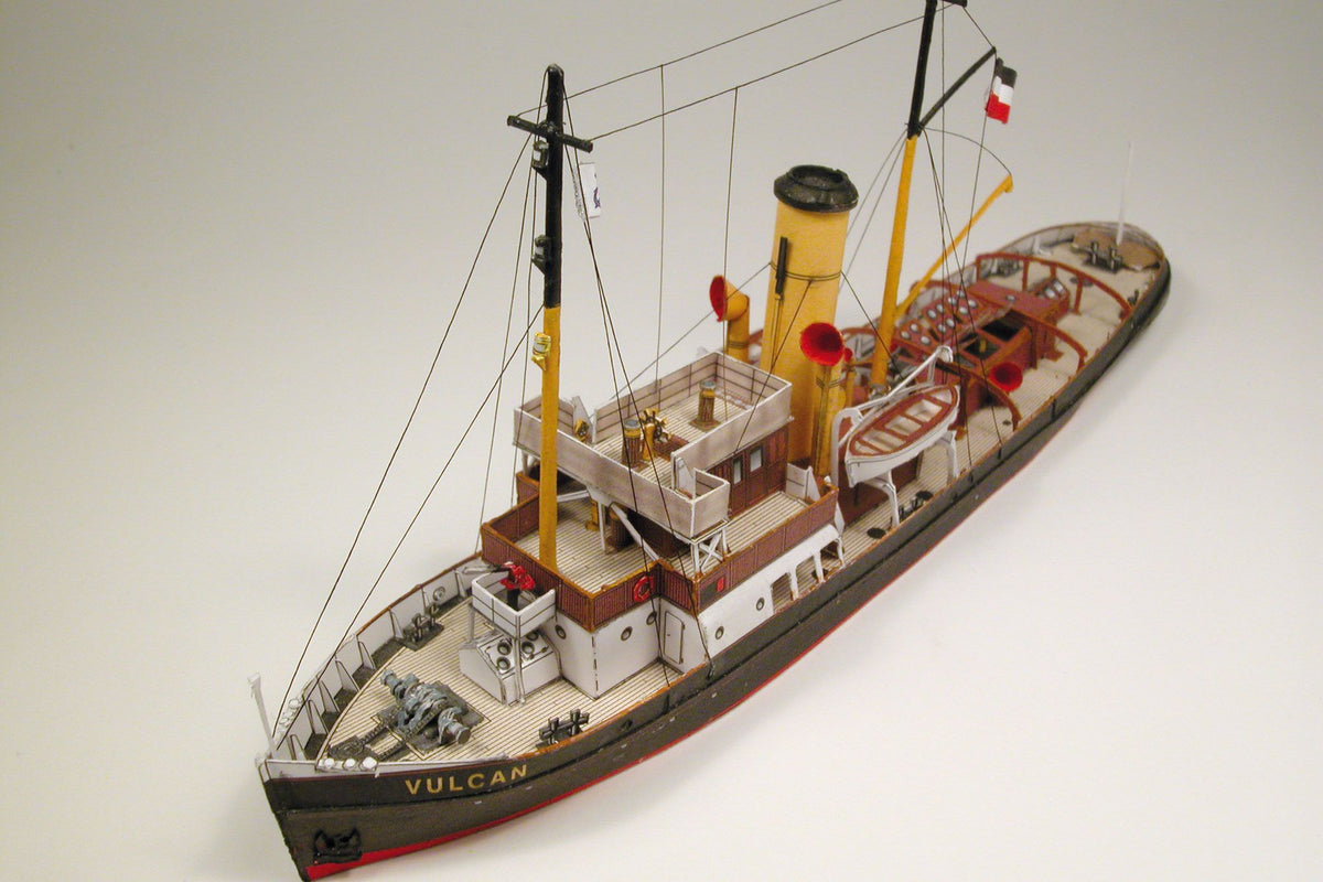 Photo of HMV Merkur and Vulkan 1/250 scale tugboat card model kit showing detailed steam tugs with printed parts and maritime accessories.