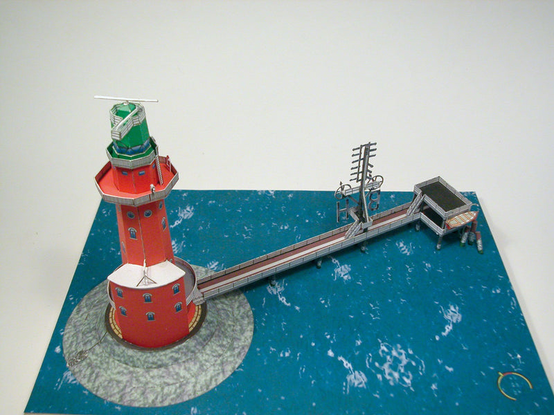 Photo of HMV Hohe Weg Aussenweser Lighthouse 1:250 card model kit showing detailed paper parts, wind semaphore, and water base.