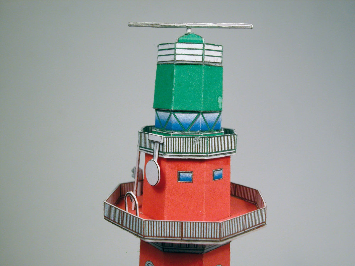 Photo of HMV Hohe Weg Aussenweser Lighthouse 1:250 card model kit showing detailed paper parts, wind semaphore, and water base.