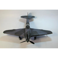A detailed model of a classic military fighter plane, photographed from a top-down perspective against a neutral light gray background.