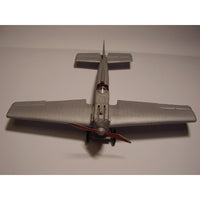 A silver model airplane photographed from above on a plain light background.