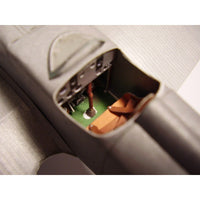 Close-up of a miniature model airplane cockpit interior, showing a green floor, brown seats, and gray fuselage with a clear windshield.