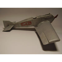 A silver model airplane, likely a foam model, featuring red Cyrillic text and a red star insignia on the side, displayed against a neutral gray background.