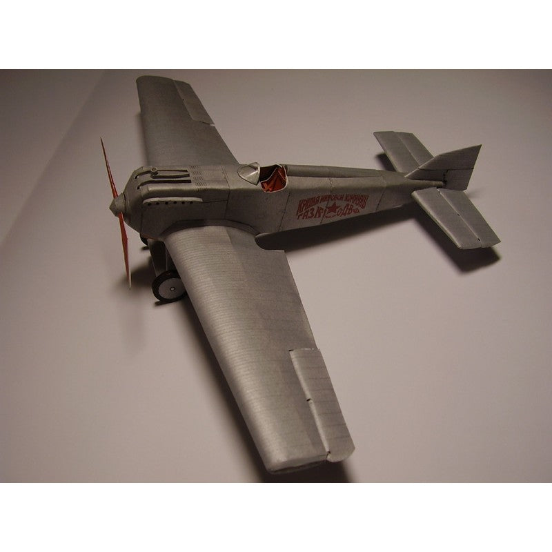 A silver model airplane with red lettering on the side, photographed on a plain light gray background.