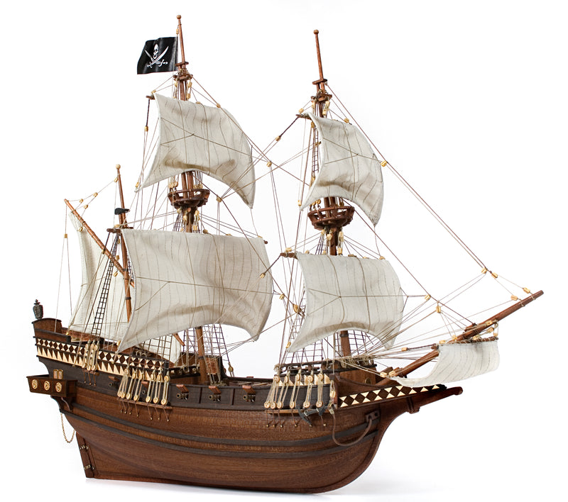 Photo of OcCre Buccaneer Pirate Ship 1:100 Wooden Model Kit fully assembled, showing detailed sails, wooden hull, and rigging.