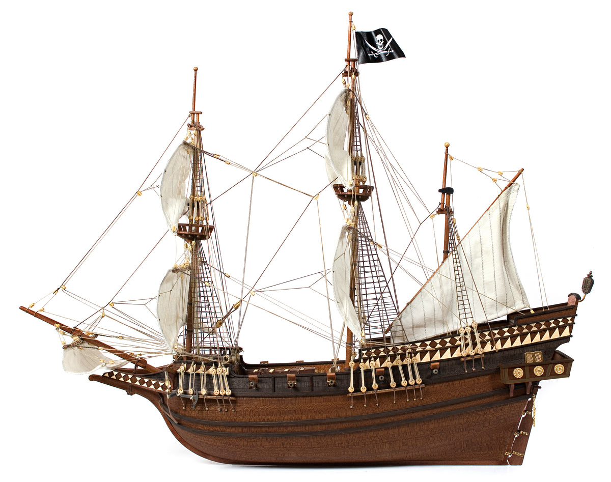 Photo of OcCre Buccaneer Pirate Ship 1:100 Wooden Model Kit fully assembled, showing detailed sails, wooden hull, and rigging.