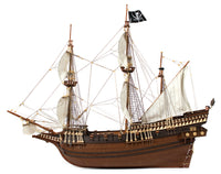 Photo of OcCre Buccaneer Pirate Ship 1:100 Wooden Model Kit fully assembled, showing detailed sails, wooden hull, and rigging.