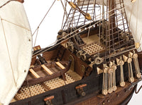 Photo of OcCre Buccaneer Pirate Ship 1:100 Wooden Model Kit fully assembled, showing detailed sails, wooden hull, and rigging.