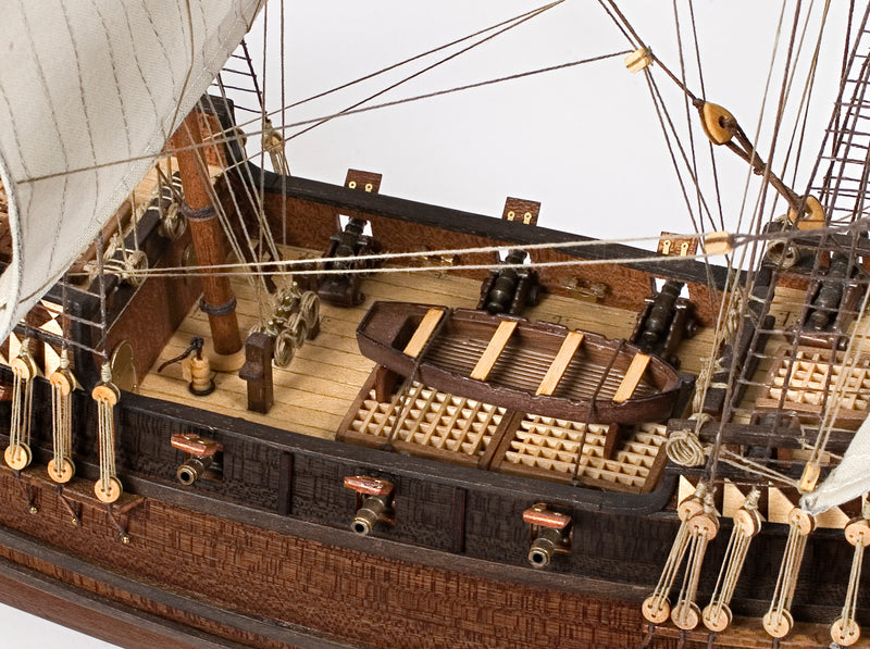 Photo of OcCre Buccaneer Pirate Ship 1:100 Wooden Model Kit fully assembled, showing detailed sails, wooden hull, and rigging.
