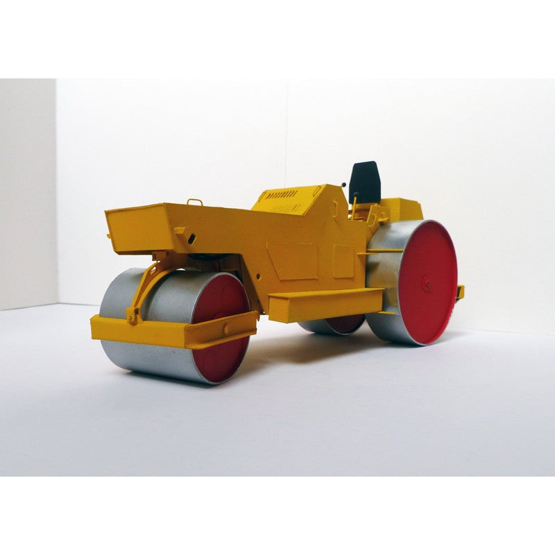 A miniature yellow road roller toy or model, featuring a bright yellow body, silver-gray metal drum wheels with red-painted faces, and a small black seat, displayed on a clean white studio background.