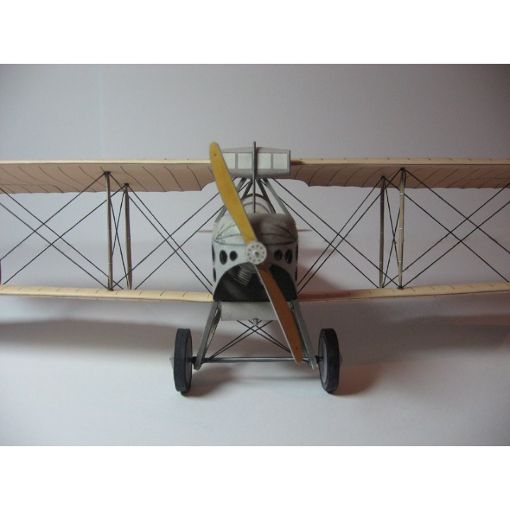 A vintage-style biplane model or toy airplane with a silver and black fuselage, yellow propeller blade, and light wood-toned wings, shown against a plain light gray background.