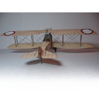 A vintage-style biplane model or miniature aircraft shown from the rear three-quarter view on a plain light gray studio background.