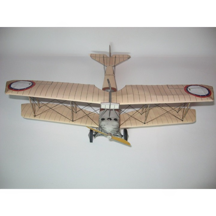 A vintage-style biplane model or toy airplane shown from above against a plain light background. The wings are a warm beige/tan with thin dark striping, the fuselage is gray, and the propeller is yellow with black blades.
