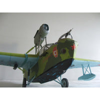 A model of a vintage military seaplane with a green camouflage fuselage, light blue wings and floats, and red star insignia, photographed against a plain light gray background.