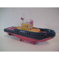 A model tugboat toy or miniature boat displayed on a stand against a plain light background. The boat has a yellow cabin, a dark blue-gray hull, a pink-red lower hull, and white text reading “RBT-140” on the side.
