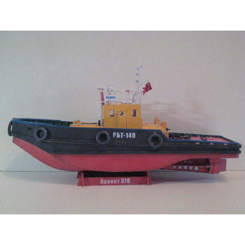 A model tugboat displayed on a stand against a plain light gray background. The boat features a dark blue-black hull, a red lower hull, and a yellow cabin.