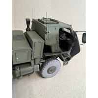 A detailed model of an olive green military truck, shown from a high-angle perspective with the side door open, set against a neutral beige background.