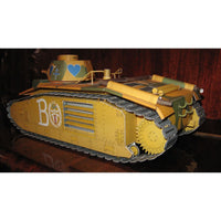 A detailed 3D paper model of a military tank, painted in a yellow and olive green camouflage scheme with a blue heart on the turret and a large white letter 'B' on the side, displayed on a dark reflective surface.