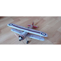 A vintage-style biplane model or toy airplane with a white and gray striped fuselage and wings, red tail and nose details, and roundel markings, photographed on a light wood floor.