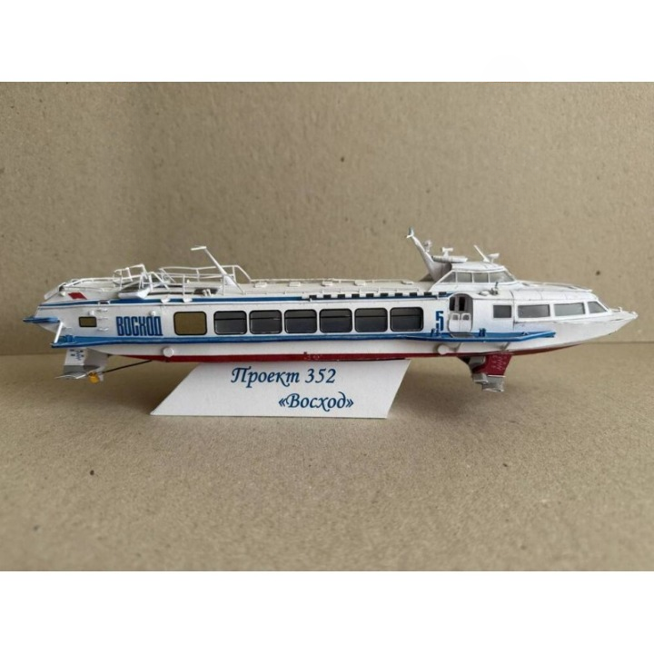 A model train of the Russian passenger ship Voskhod on a display stand, photographed against a neutral beige background.