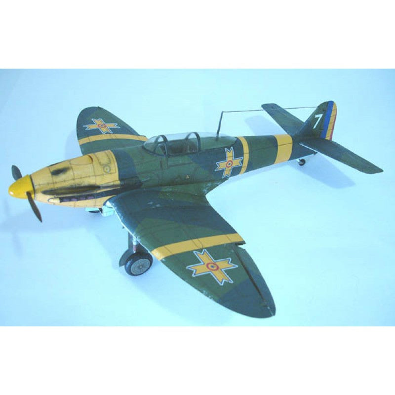 A model of a vintage military fighter plane, painted in a dark green and yellow camouflage scheme with Swedish cross insignias, shown against a light blue gradient background.