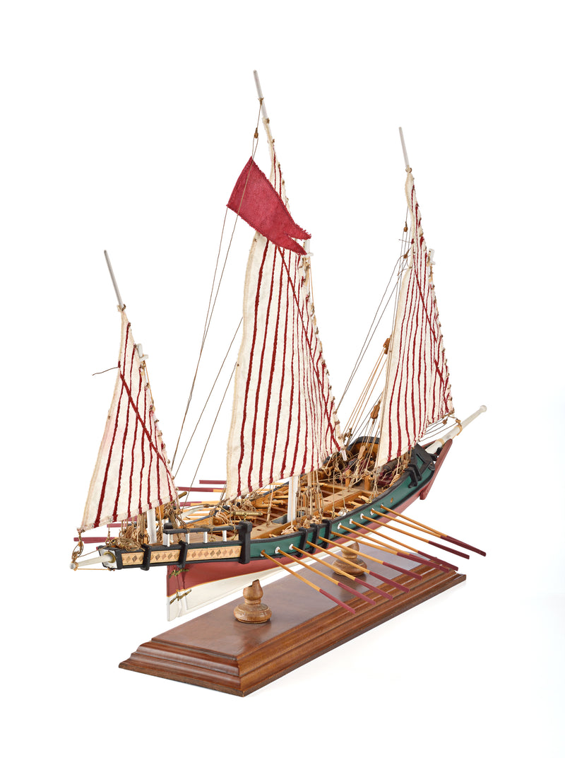 Photo of Amati Greek Galley 1:65 wooden model ship kit with sails and wooden base, depicting a historic Greek warship from the War of Independence.
