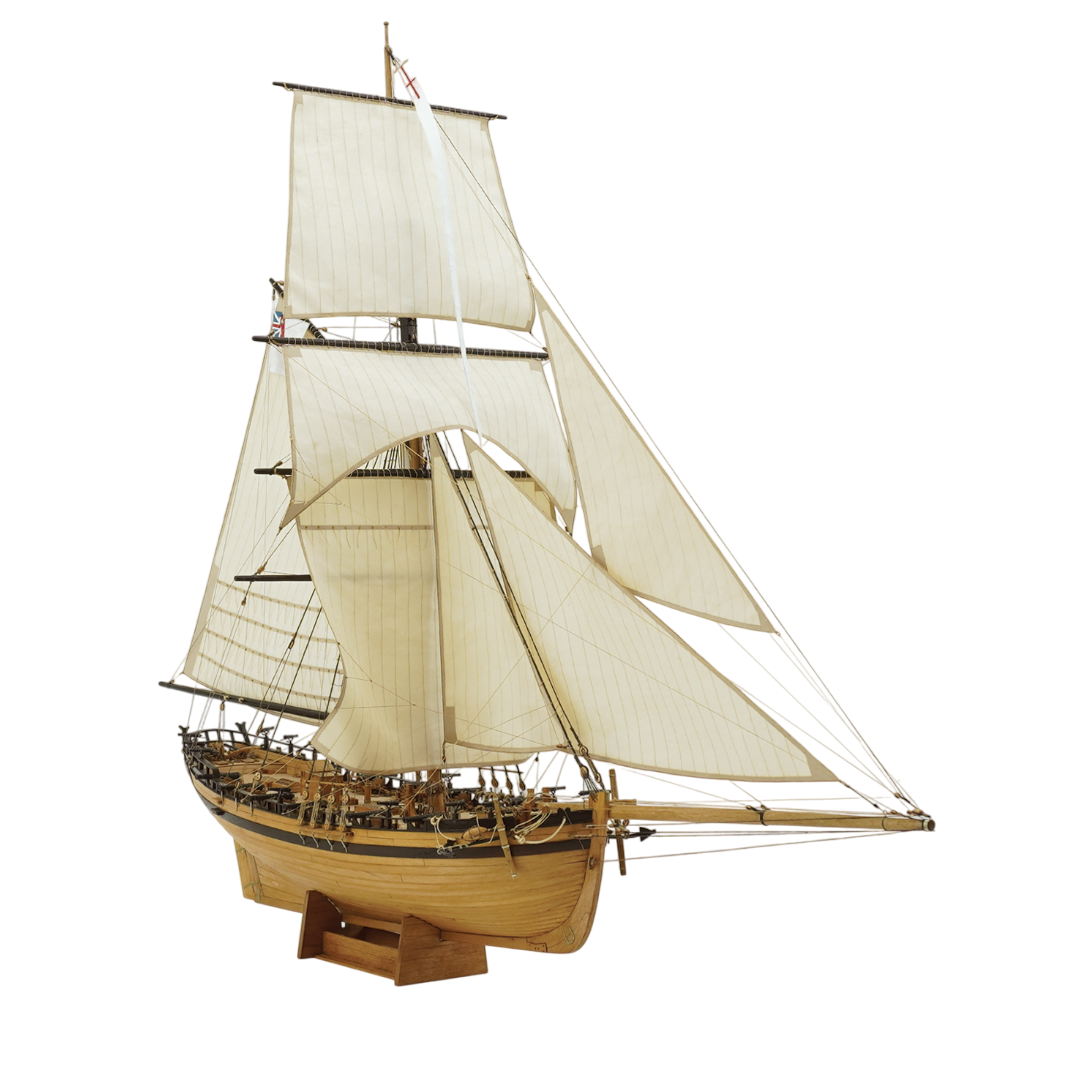 Photo of the HMS Rattlesnake 1776 wooden model kit by Shipyard in 1:72 scale, showing laser-cut parts, brass details, rigging accessories, and sails.